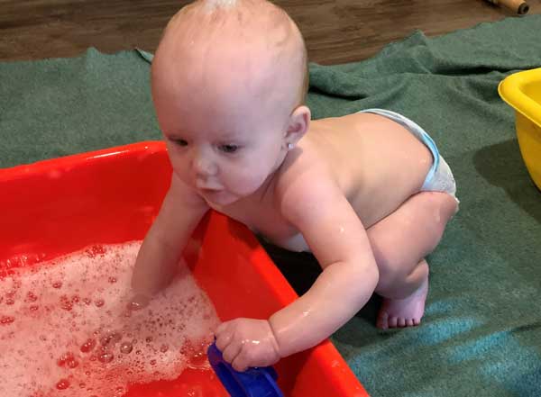 Sprout splashing in water sensory bin